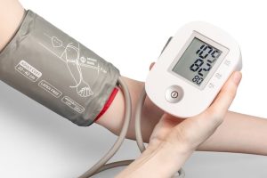 Person measuring blood pressure with sphygmomanometer